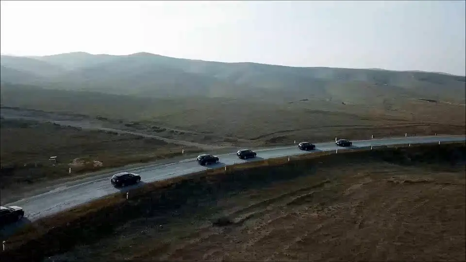 Una fila de coches negros por una carretera de montaña